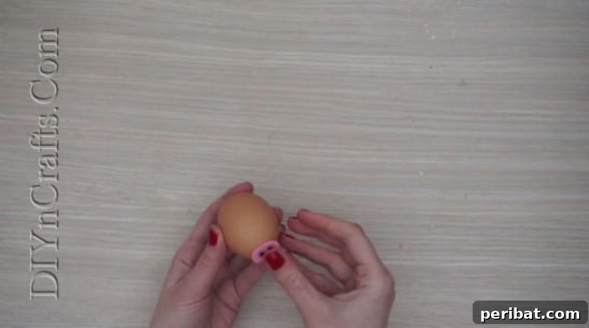 5 Delightful & Simple Easter Egg Crafts 13 Gluing the pink felt snout onto the Easter egg with a hot glue gun.