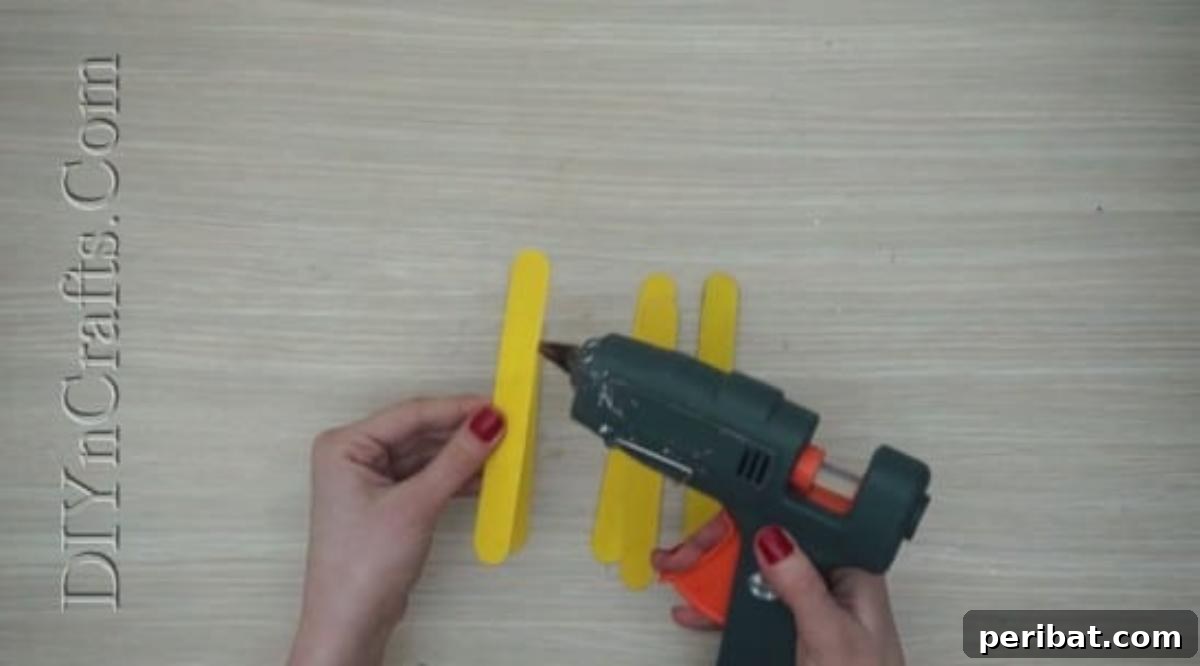 Craft Stick Easter Magic: 5 Simple DIY Projects 16 Five yellow craft sticks glued side-by-side to form the chick's body