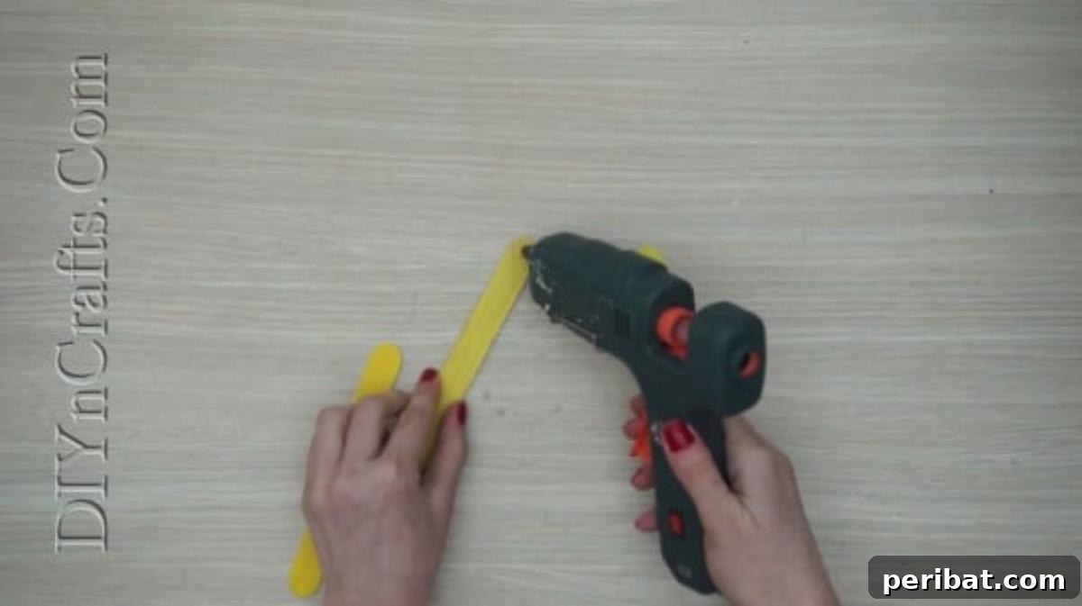 Craft Stick Easter Magic: 5 Simple DIY Projects 22 Gluing two yellow craft sticks at an angle for the chick's body