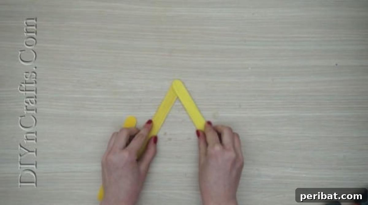 Craft Stick Easter Magic: 5 Simple DIY Projects 23 Adding the third yellow craft stick to complete the triangle base