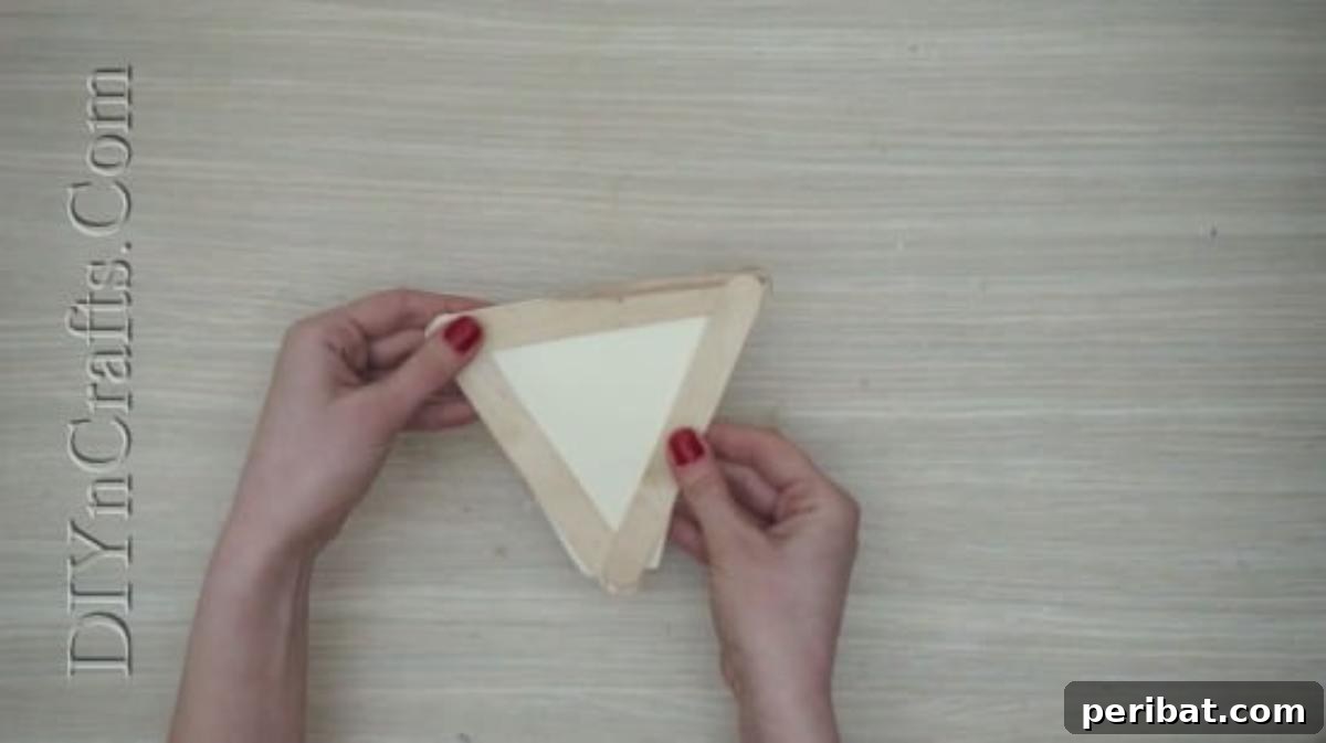Craft Stick Easter Magic: 5 Simple DIY Projects 4 White construction paper triangle glued to the back of the craft stick frame for the bunny's face