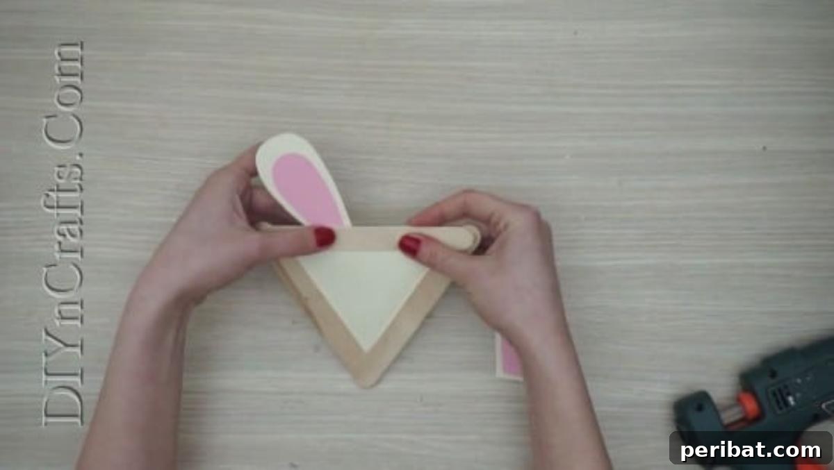 Craft Stick Easter Magic: 5 Simple DIY Projects 5 White and pink construction paper bunny ears glued to the back of the craft stick triangle