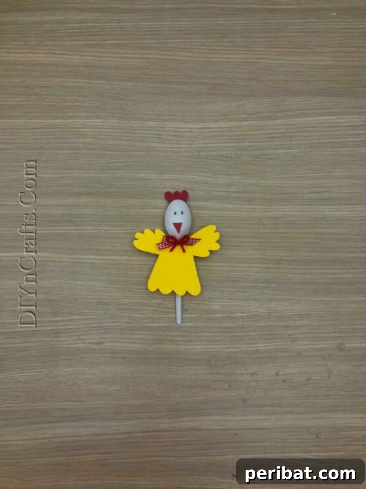 Spoonfuls of Fun 5 Easter Crafts for Kids Using Plastic Spoons 18 The completed Chick Spoon 1 craft, featuring a plastic spoon with a yellow paper body, wings, a red comb and beak, and drawn eyes.