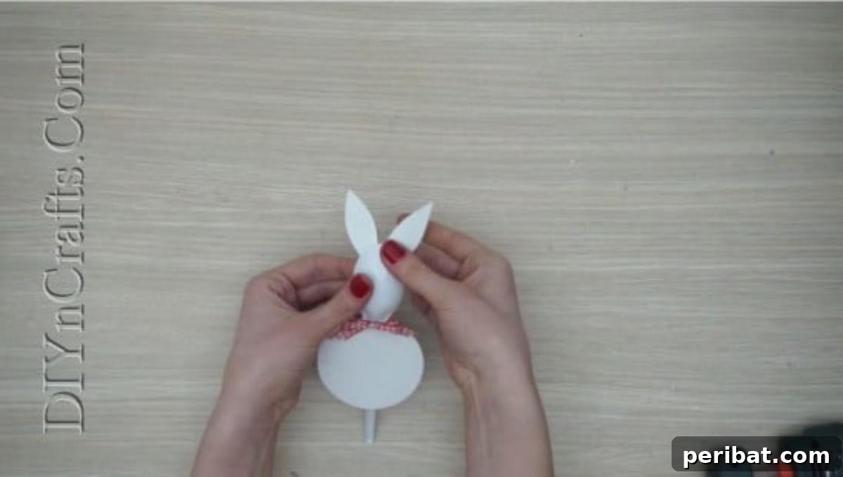 Spoonfuls of Fun 5 Easter Crafts for Kids Using Plastic Spoons 22 The plastic spoon bunny now has white paper ears and a bow attached to its head, complementing its round paper body.