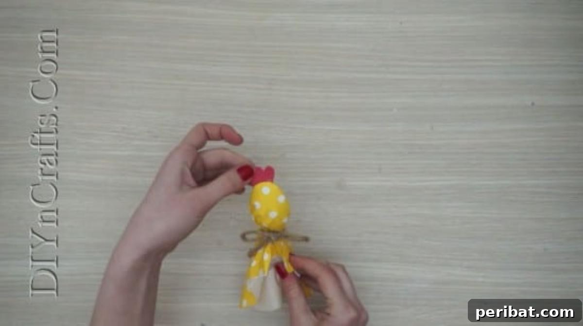 Spoonfuls of Fun 5 Easter Crafts for Kids Using Plastic Spoons 27 A red paper comb is being glued onto the top of the tissue-paper-covered plastic spoon, forming the chick's headpiece.