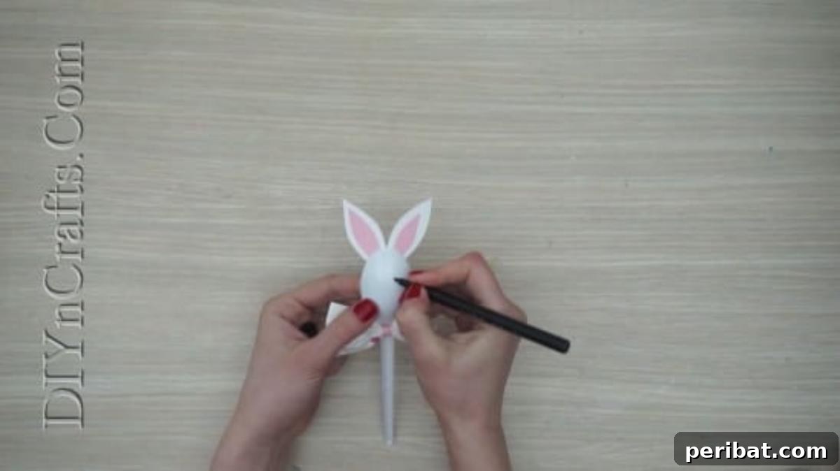 Spoonfuls of Fun 5 Easter Crafts for Kids Using Plastic Spoons 7 A black marker is being used to draw a charming bunny face onto the convex side of the plastic spoon, bringing the craft to life.