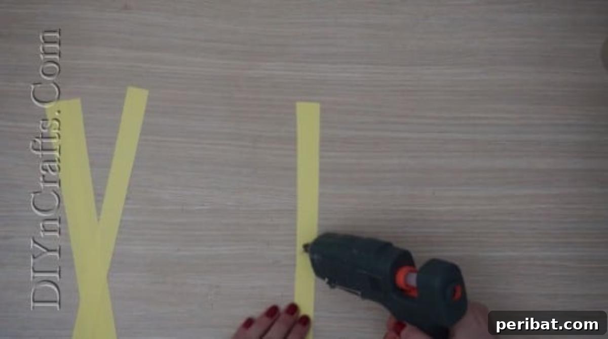 Instant Easter Fun: 5 Crafts for Kids in Under 5 Minutes 20 Gluing two yellow paper strips together at their centers to form a cross shape for the chick's body.