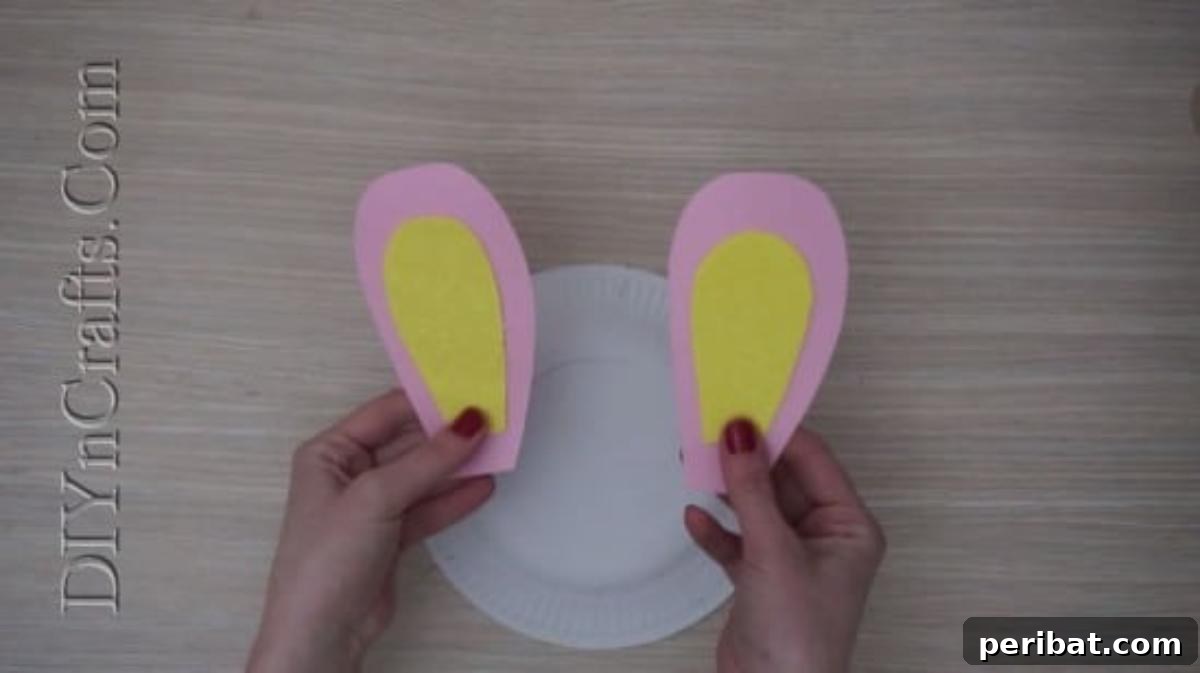 Instant Easter Fun: 5 Crafts for Kids in Under 5 Minutes 3 Crafting bunny ears from pink and yellow construction paper for the paper plate bunny project.