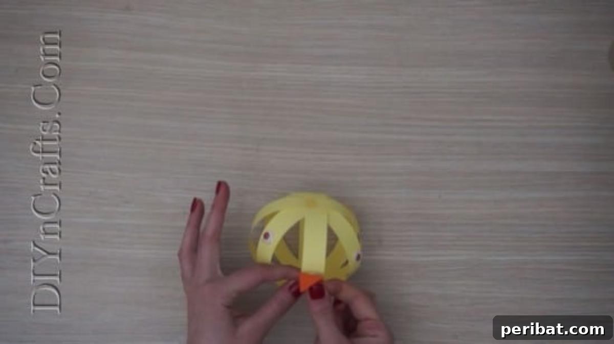 Instant Easter Fun: 5 Crafts for Kids in Under 5 Minutes 25 Adding an orange construction paper beak and two googly eyes to the paper strip chick.