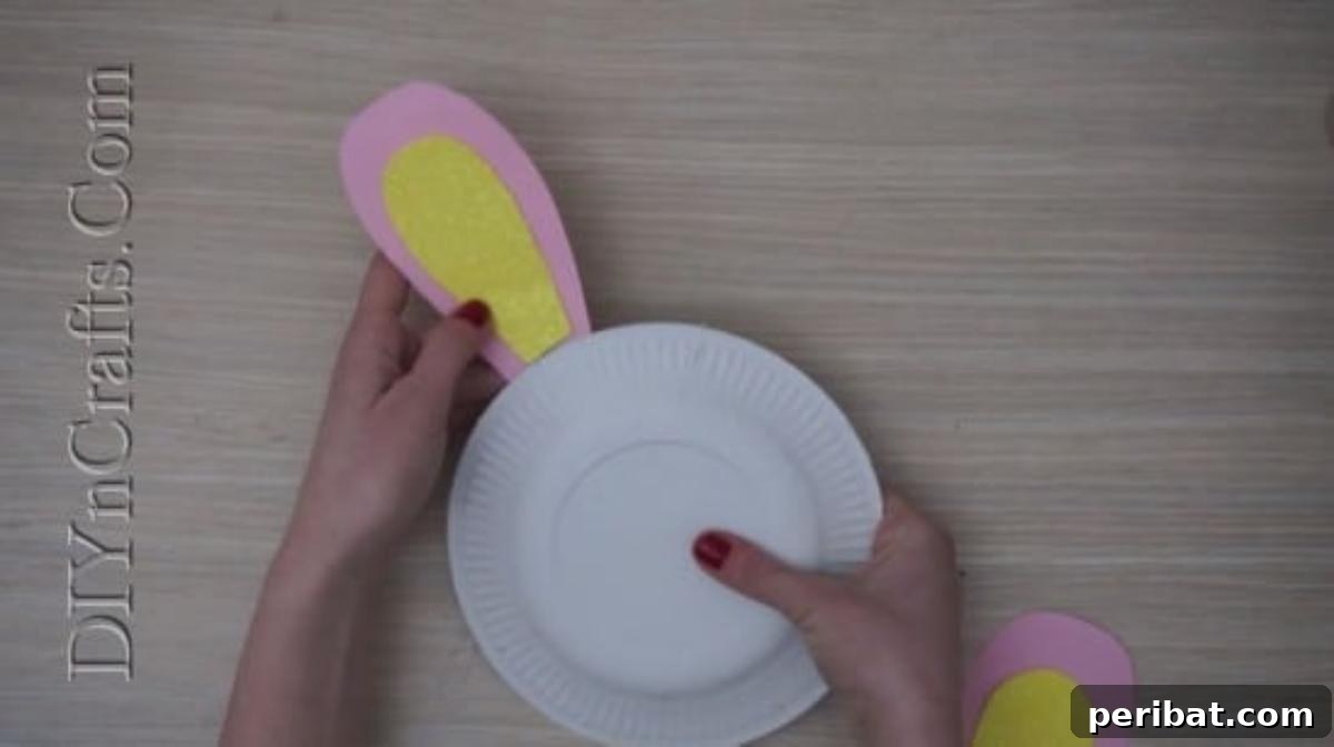 Instant Easter Fun: 5 Crafts for Kids in Under 5 Minutes 4 Gluing colorful construction paper bunny ears onto the top of a white paper plate.