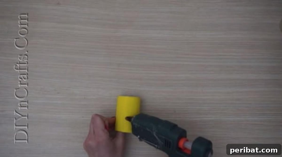 Instant Easter Fun: 5 Crafts for Kids in Under 5 Minutes 9 Attaching an orange triangle beak to the yellow paper roll, forming the Easter chick's face.