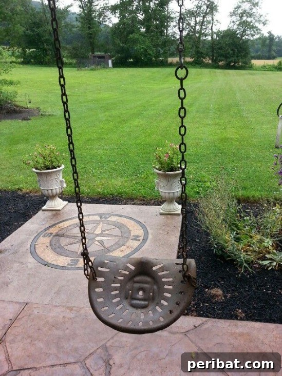 Rustic Charm: 10 Creative Farm Equipment Upcycles for Home & Garden Decor 11 Rustic DIY swing made from a vintage tractor seat hanging in a garden