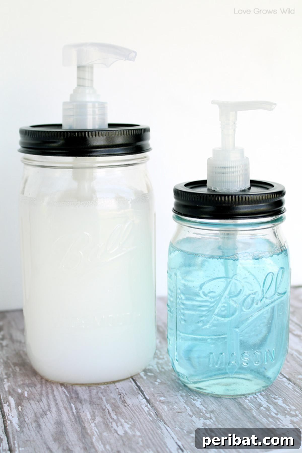 Three mason jar soap dispensers with rustic tops, adding a vintage touch to a kitchen sink.