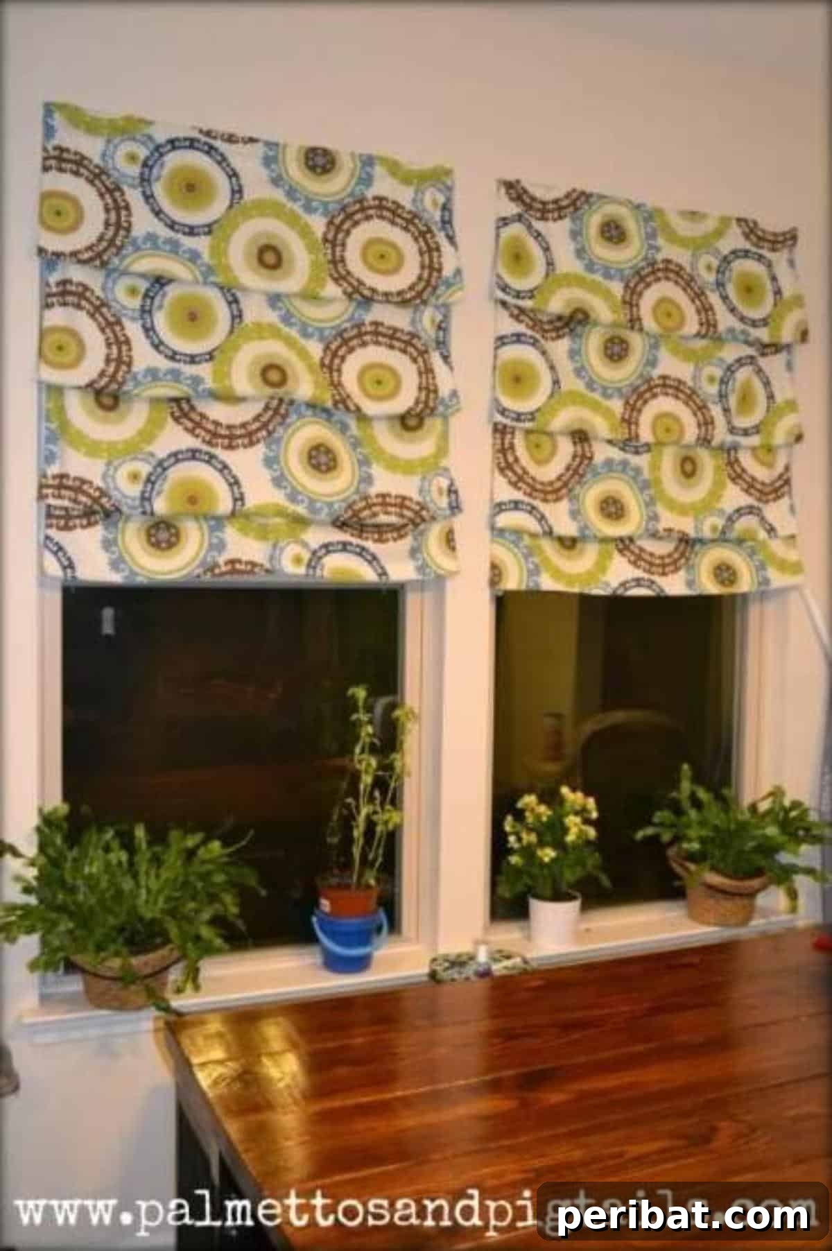A stylish, custom-made Roman shade adorning a kitchen window, offering both privacy and light control.