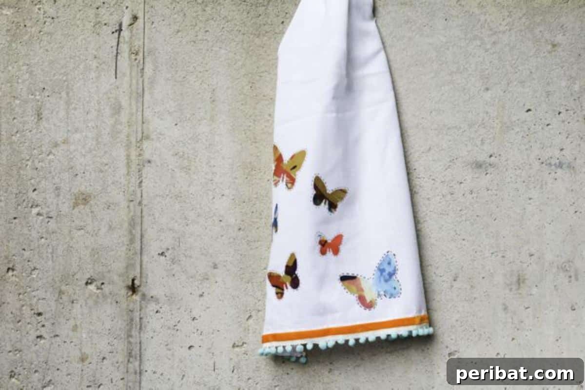 A plain white dishtowel transformed with a hand-painted floral design, ready for kitchen use.