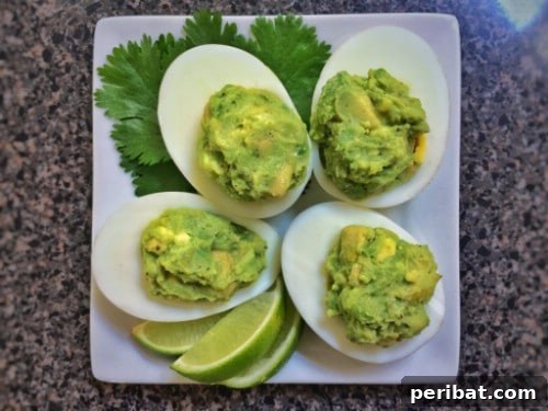 Deviled eggs with a vibrant green guacamole filling
