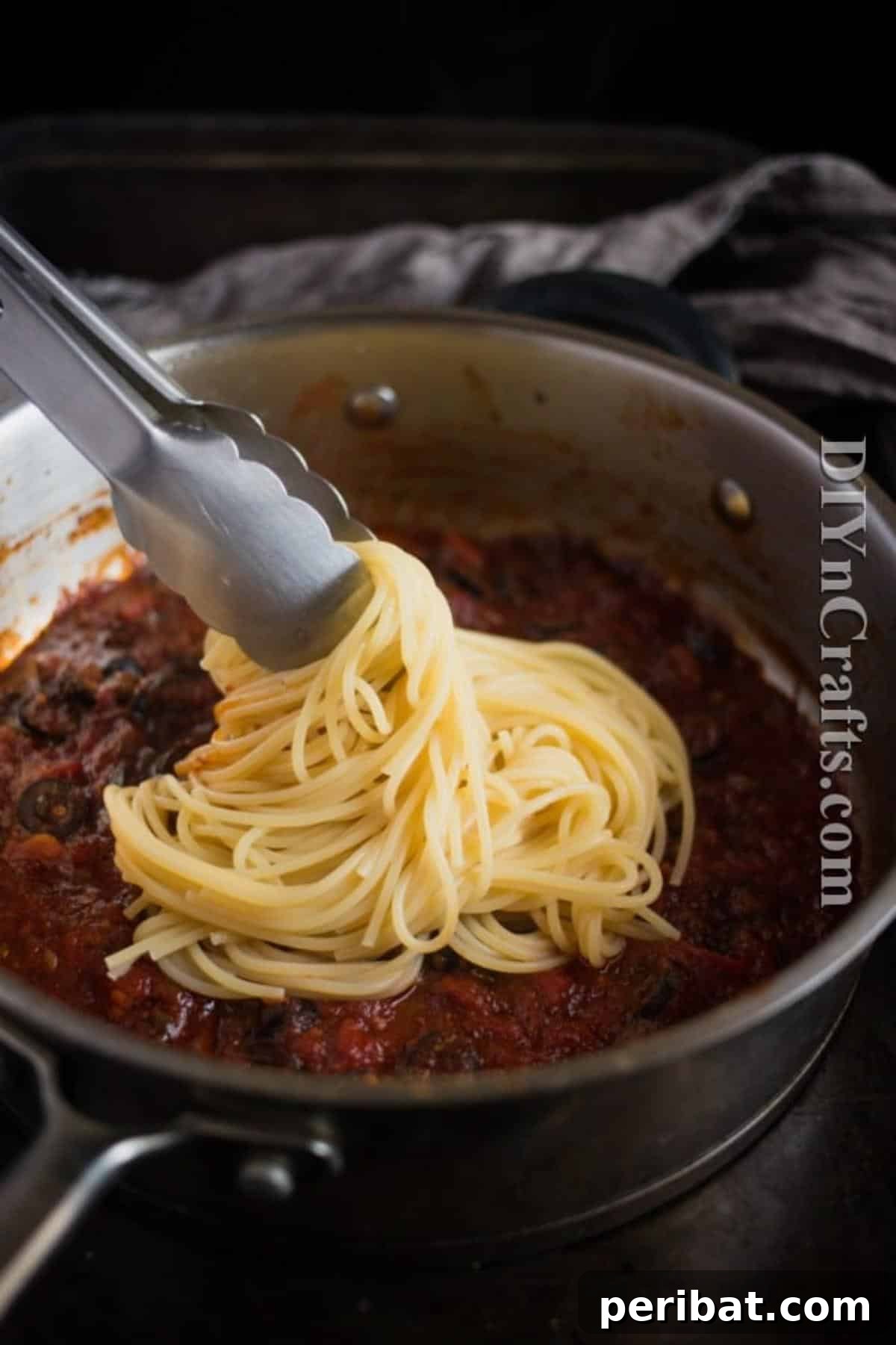 Spaghetti Puttanesca: Bold Flavors, Classic Appeal 6 Mixing spaghetti with sauce: