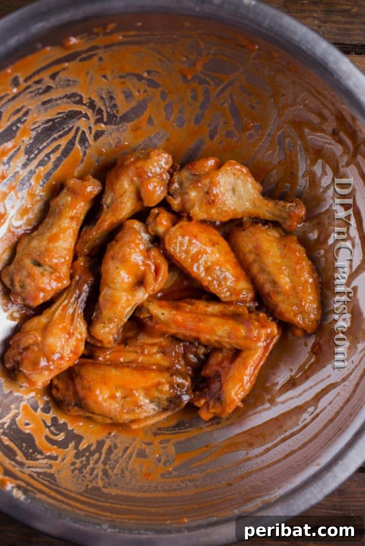 Melted butter and red hot sauce being combined in a small saucepan, creating the iconic buffalo wing sauce.