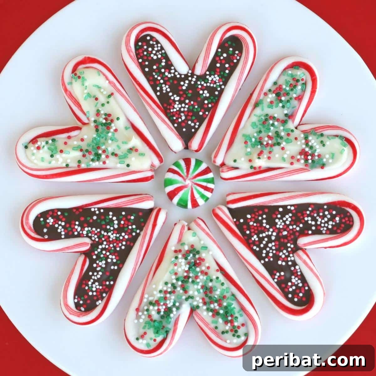 Sweet candy cane hearts filled with melted chocolate and decorated with sprinkles, on lollipop sticks.