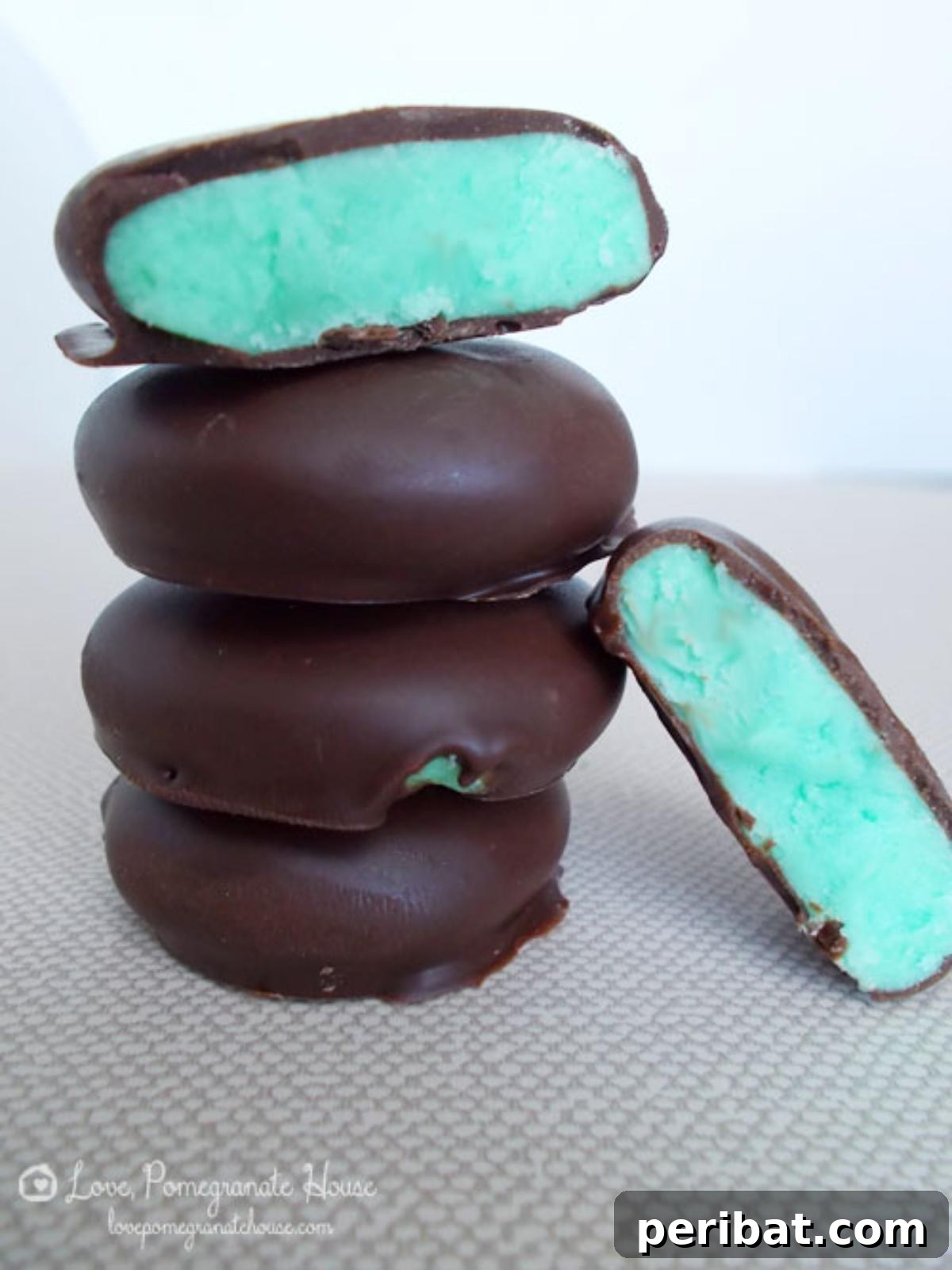 Homemade chocolate-dipped peppermint patties, some with green centers, decorated for Christmas.