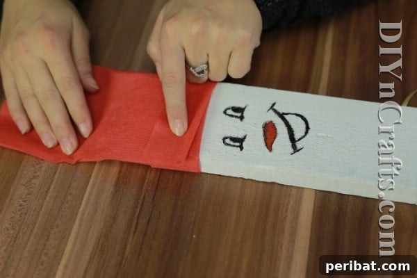 Craft Your Own Rustic Christmas Snowman 10 Creating snowman cap with red fabric and ribbon
