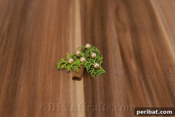 A completed rustic aromatic ornament with faux pearls attached, ready for the hanging loop.