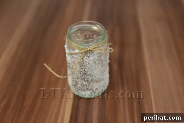 The twine tied into a neat bow around the top of the frosted jar, completing the decorative wrapping.