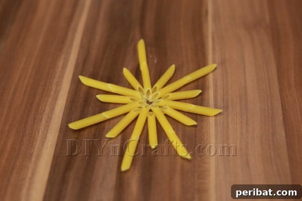 Dazzling Pasta Snowflake Christmas Ornaments 13 A completed, unpainted pasta snowflake ornament, showcasing the assembled design.