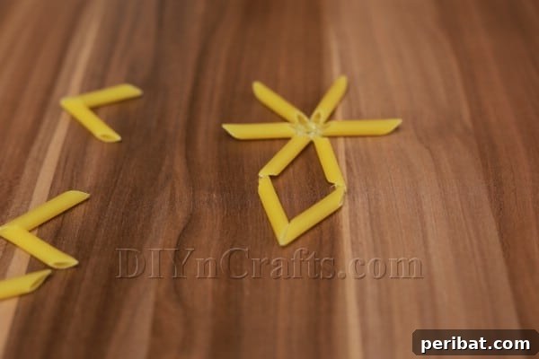 Dazzling Pasta Snowflake Christmas Ornaments 16 Attaching the chevron pasta piece to the end of a straight pasta arm.
