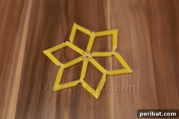 Dazzling Pasta Snowflake Christmas Ornaments 17 Assembling multiple chevron-tipped arms to form the complete snowflake structure for Design #2.