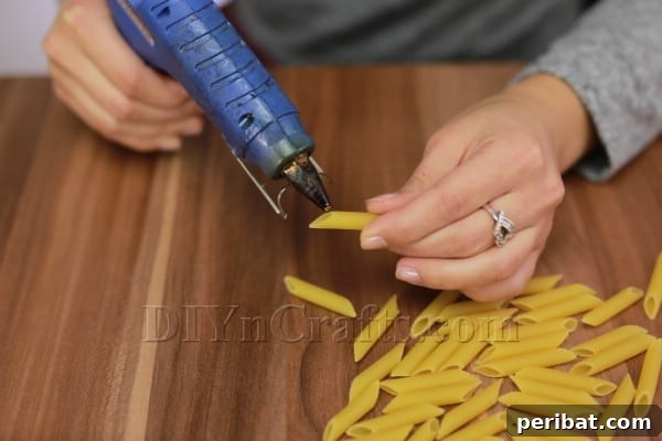 Dazzling Pasta Snowflake Christmas Ornaments 4 Combining two pieces of straight pasta end-to-end to create a longer segment for snowflake arm.