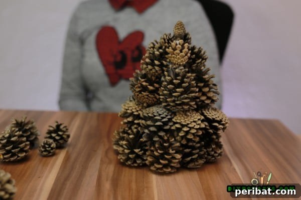 Step 7: Placing the smallest pinecone at the very top