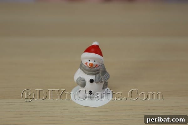 Attaching Christmas ornament to cardboard with hot glue