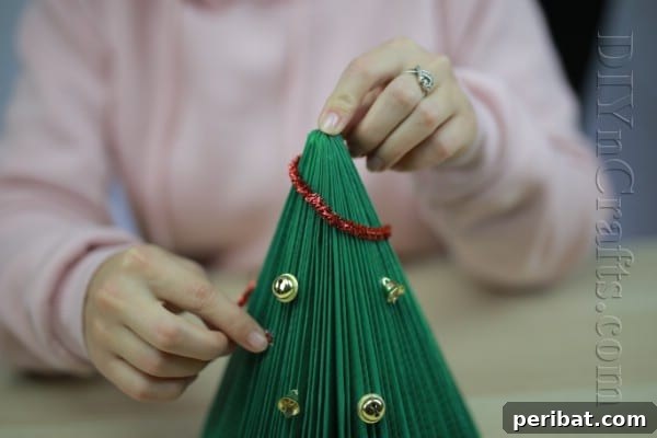 Pages to Pine: Craft a Christmas Tree from Old Books 10 Adding pipe cleaners as tinsel to the book Christmas tree