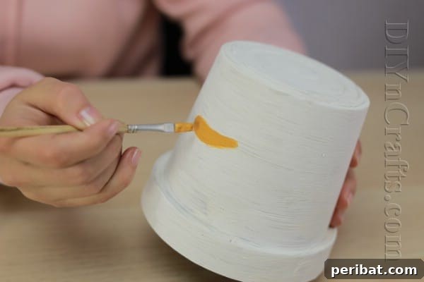 DIY Adorable Flower Pot Snowman 6 Paint the snowman's carrot nose