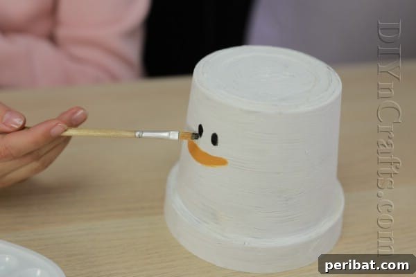 DIY Adorable Flower Pot Snowman 7 Paint the snowman's black eyes