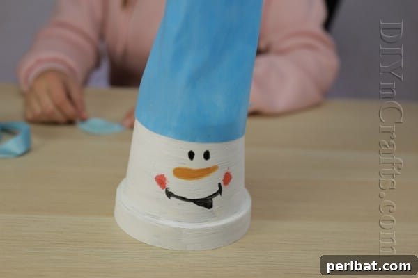 DIY Adorable Flower Pot Snowman 9 Wrap fabric around the snowman's head for the hat