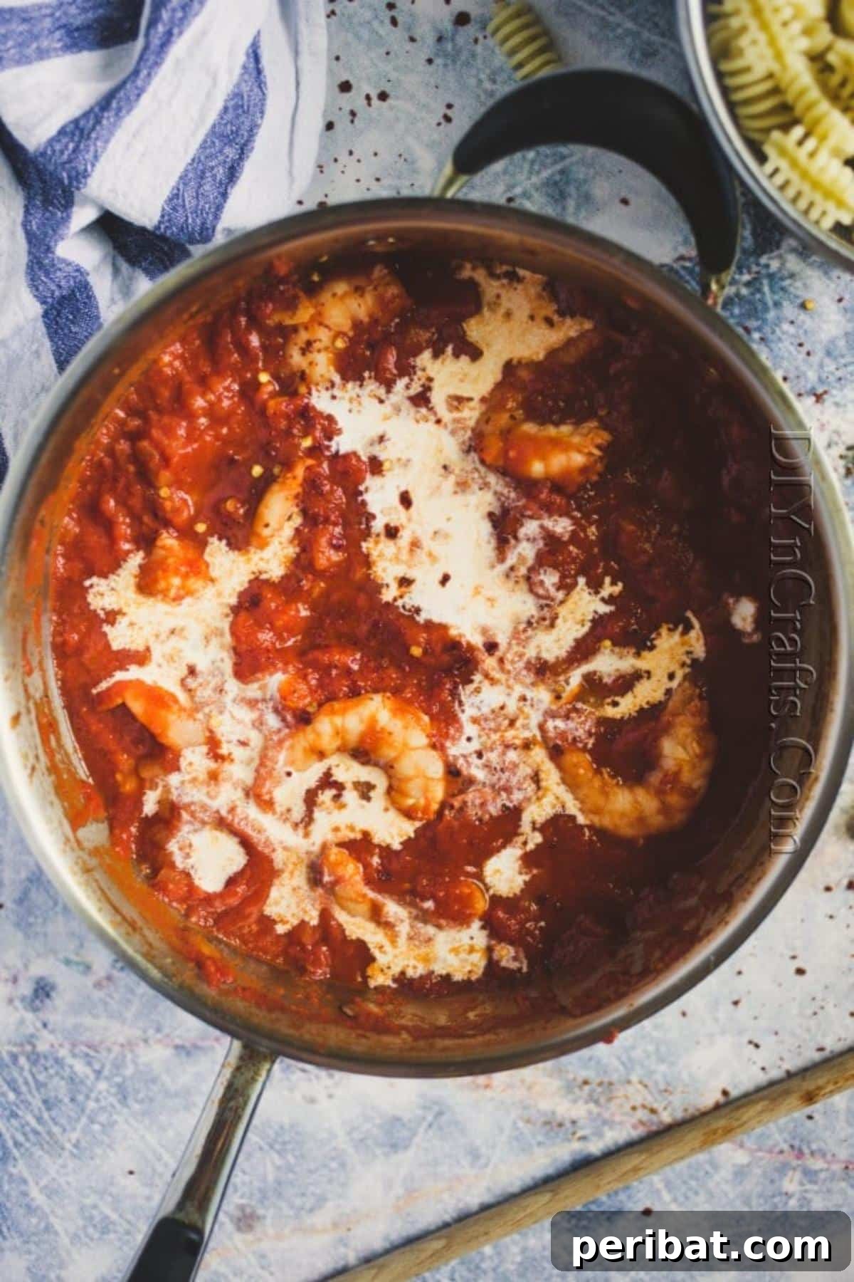 Adding cream to the cooked pasta sauce.