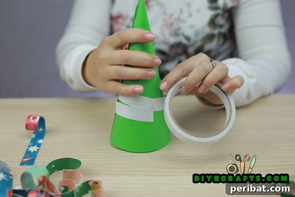 Miniature Cardstock Strip Christmas Tree Craft 13 Applying double-stick tape around the base of the cone