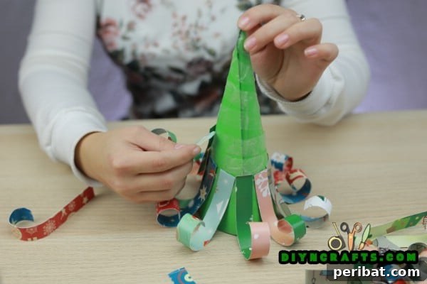 Miniature Cardstock Strip Christmas Tree Craft 16 Attaching the first layer of curled cardstock strips to the cone base
