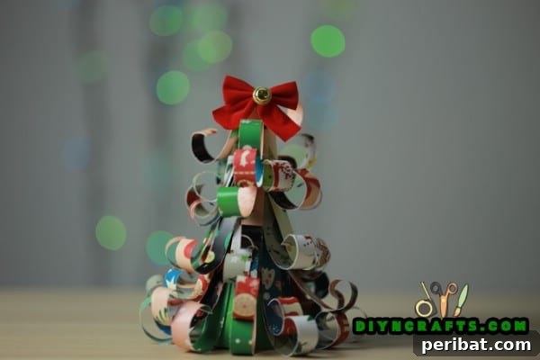 A beautifully crafted miniature Christmas tree made from cardstock strips, ready for display.