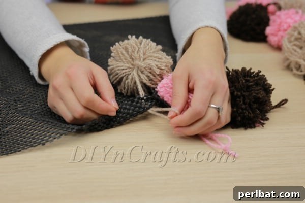 Beautiful DIY Pom Pom Rugs Made Easy 14 Tying pom pom yarn underneath rug pad