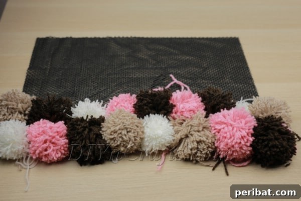 Beautiful DIY Pom Pom Rugs Made Easy 17 Working on attaching pom poms to rug pad, row by row