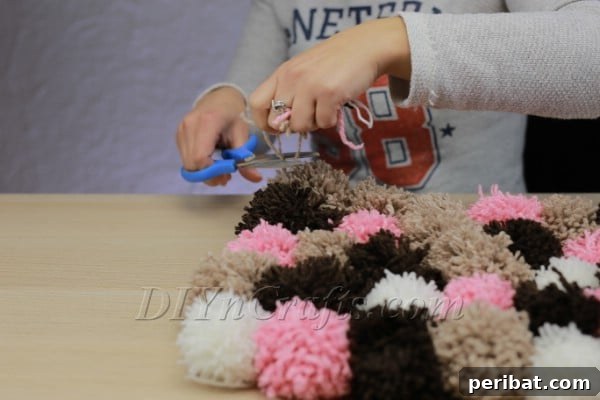 Progress shot of pom poms attached to rug pad