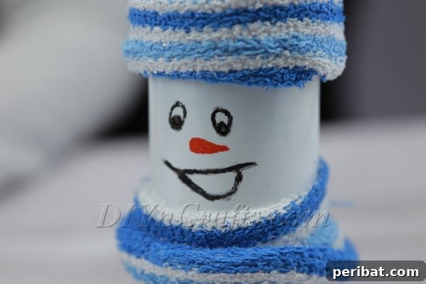 Transform Bottles into Cute Snowmen 11 Adding the final touch: painting the orange carrot nose on the bottle snowman