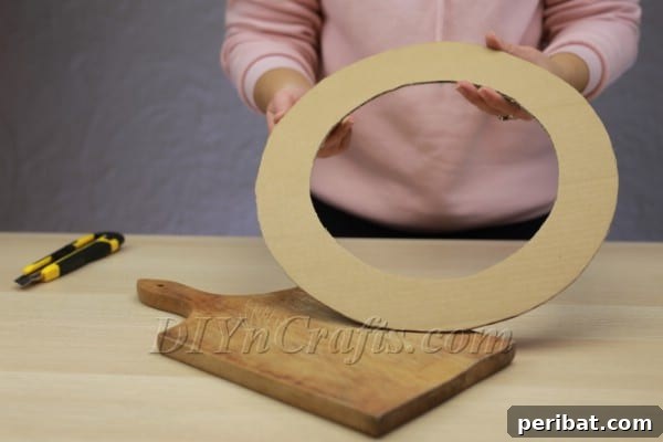 Create A Rustic Cardboard And Yarn Christmas Wreath 5 Wrapping fabric strips around the cardboard wreath frame.