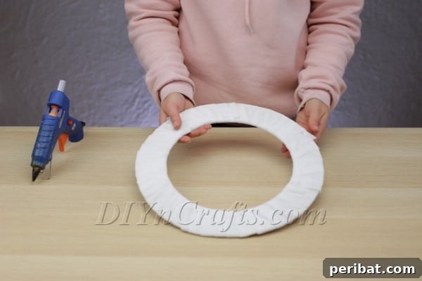 Create A Rustic Cardboard And Yarn Christmas Wreath 8 Adding pine sprigs to the wreath for a natural touch.