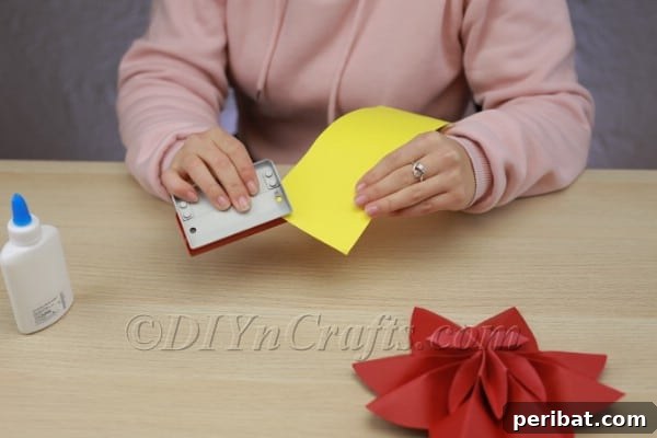 Transform Construction Paper into Festive Poinsettias 13 Step 11: Punching out small circles for the center