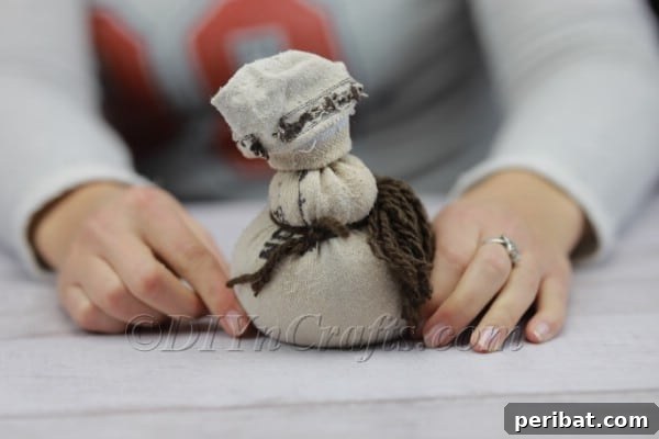 Craft Your Own Scandinavian Rice Sock Gnome 11 Attaching the yarn beard to the rice-filled sock body using a secure knot