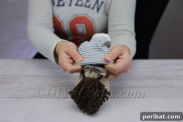 Craft Your Own Scandinavian Rice Sock Gnome 17 Carefully placing the colorful sock onto the gnome's head to form the hat
